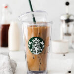 ice brown sugar latte in a starbucks cup with the lid hanging off the side