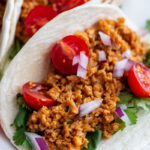 up close shot of a soft taco filled with tvp taco meat and fresh veggies
