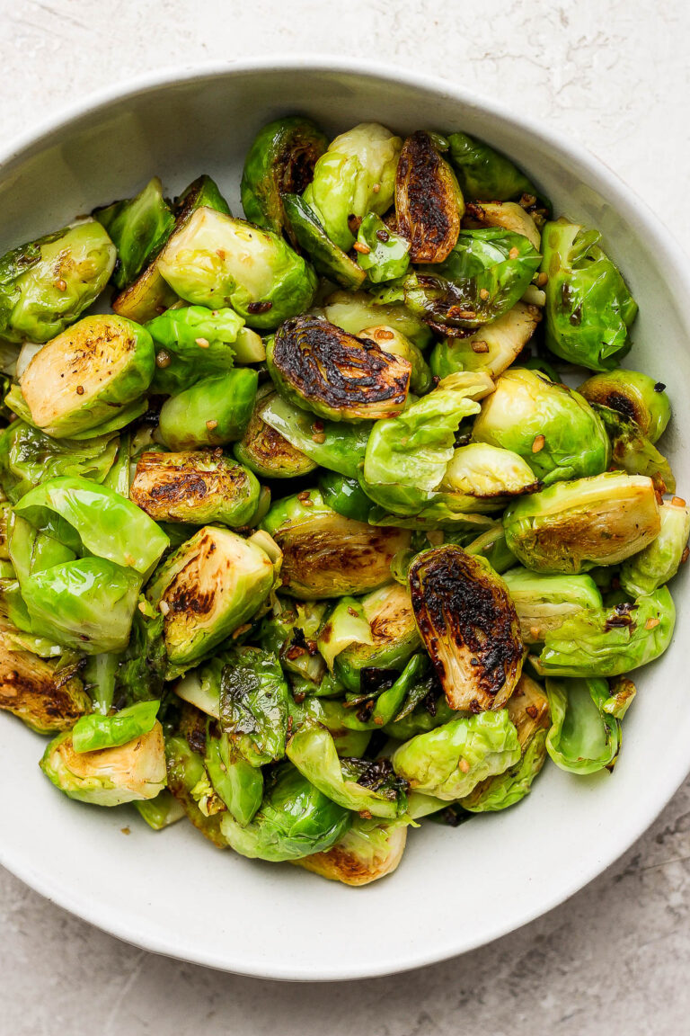 Crispy Brussels sprouts in a large white bowl.