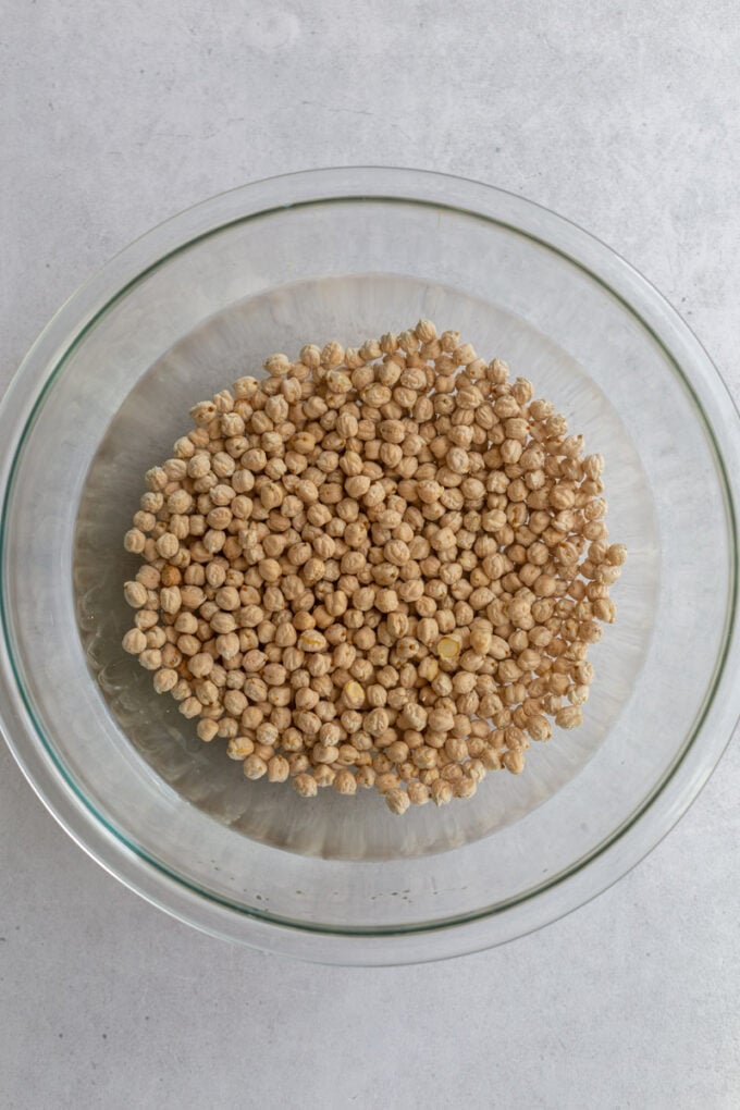 glass bowl filled with chickpeas covered in water