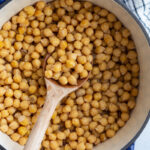 big pot of cooked chickpeas with a wooden spoon on the side