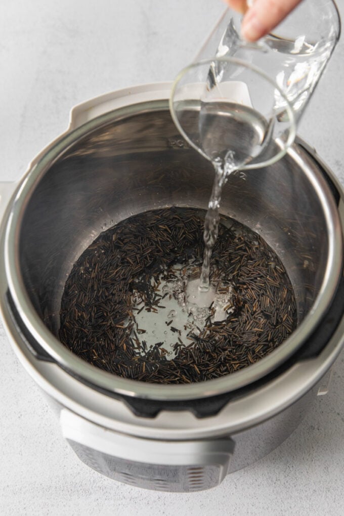 adding water to an Instant Pot with rice