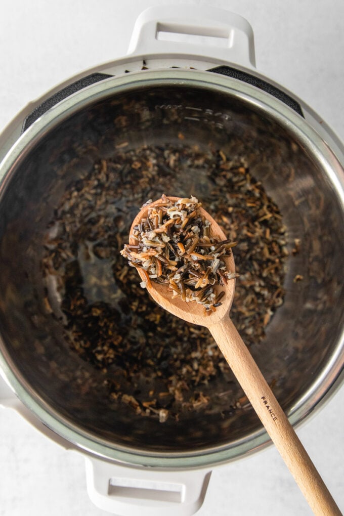 spooning wild rice out of an Instant Pot
