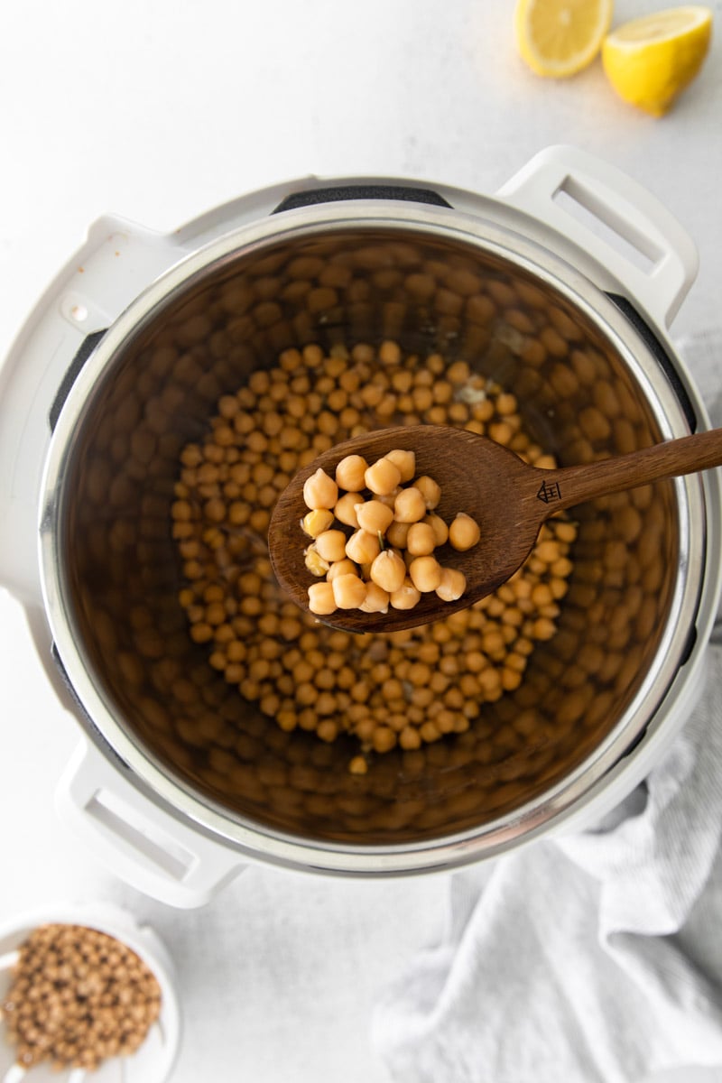 serving Instant Pot chickpeas with a wooden spoon