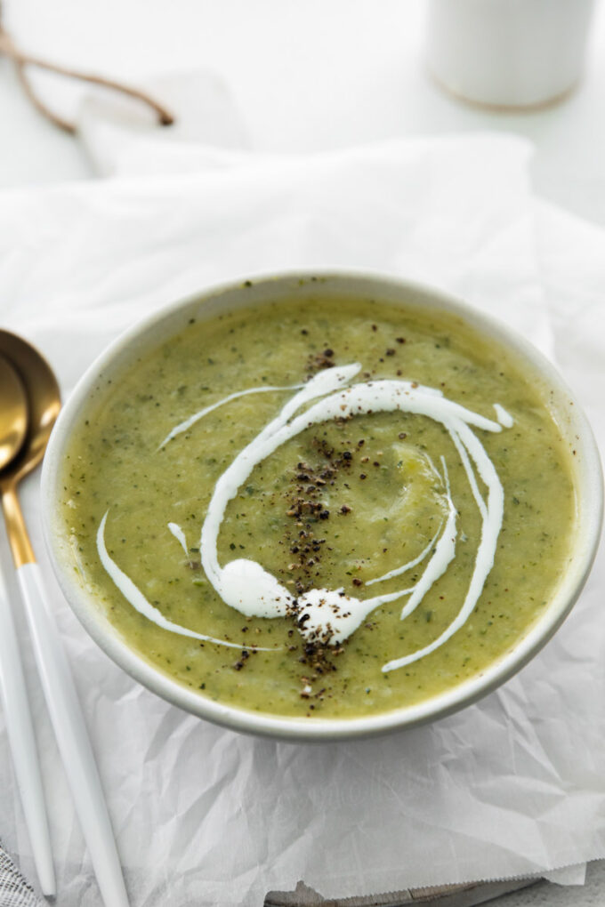 vegan zucchini soup topped with a drizzle of coconut yogurt