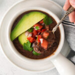black bean soup topped with avocado and diced to tomatoes