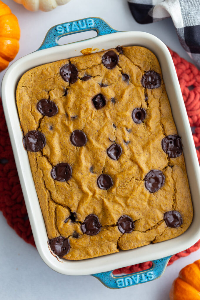 top down shot of a casserole dish with pumpkin baked oats in it with lots of chocolate chips on top