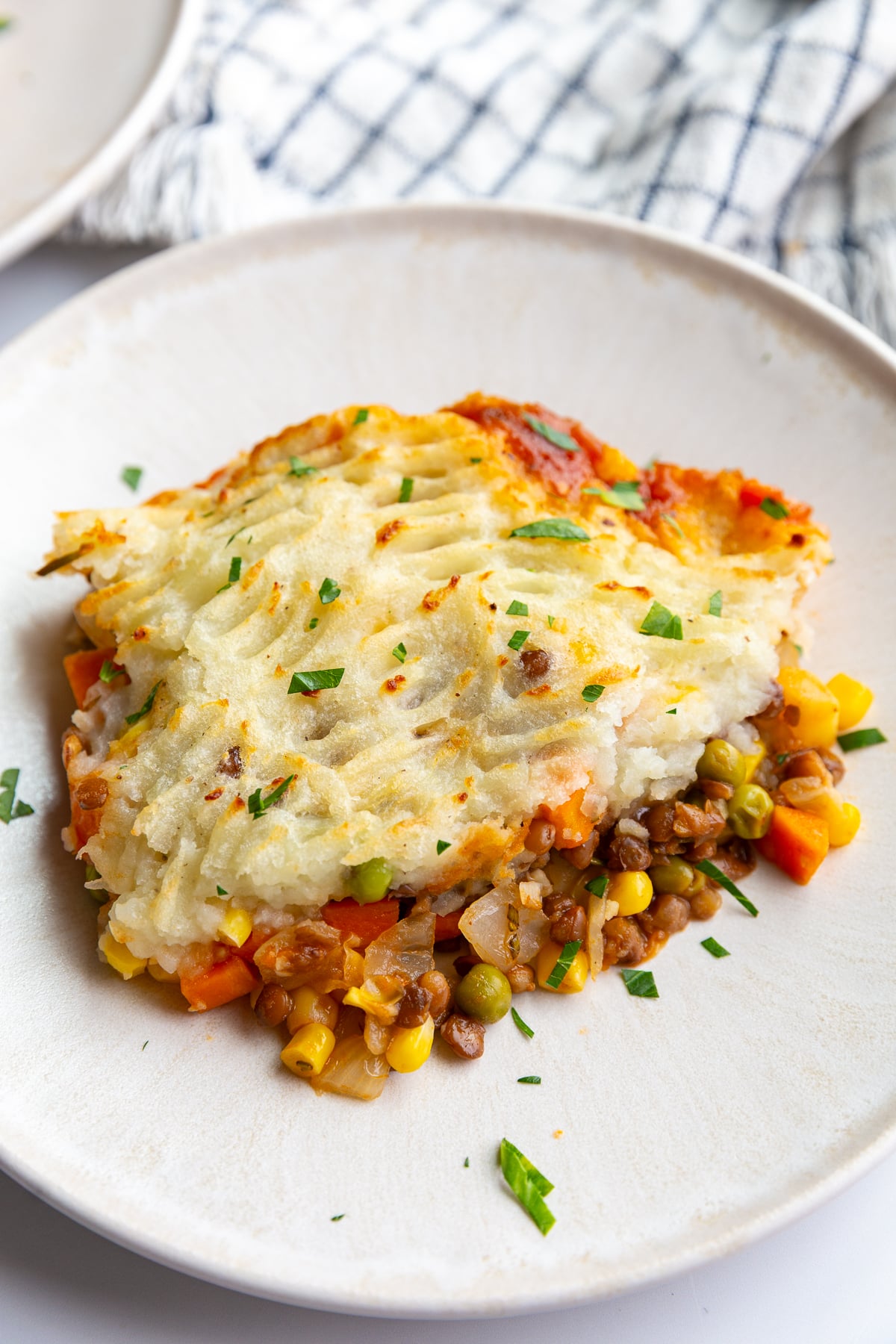 scoopful of vegetarian lentil shepherds pie on a plate