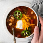 Vegetarian Taco Soup topped with sour cream, grated cheese and jalapeño slices