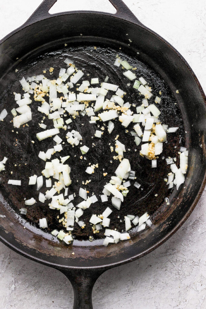 cast iron skillet with sauteed onion in it