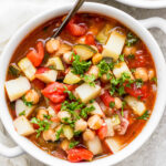 Moroccan chickpea soup served in a white bowl with a spoon.