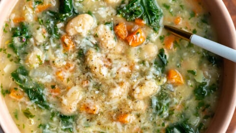 white bean and kale soup in a bowl with a spoon