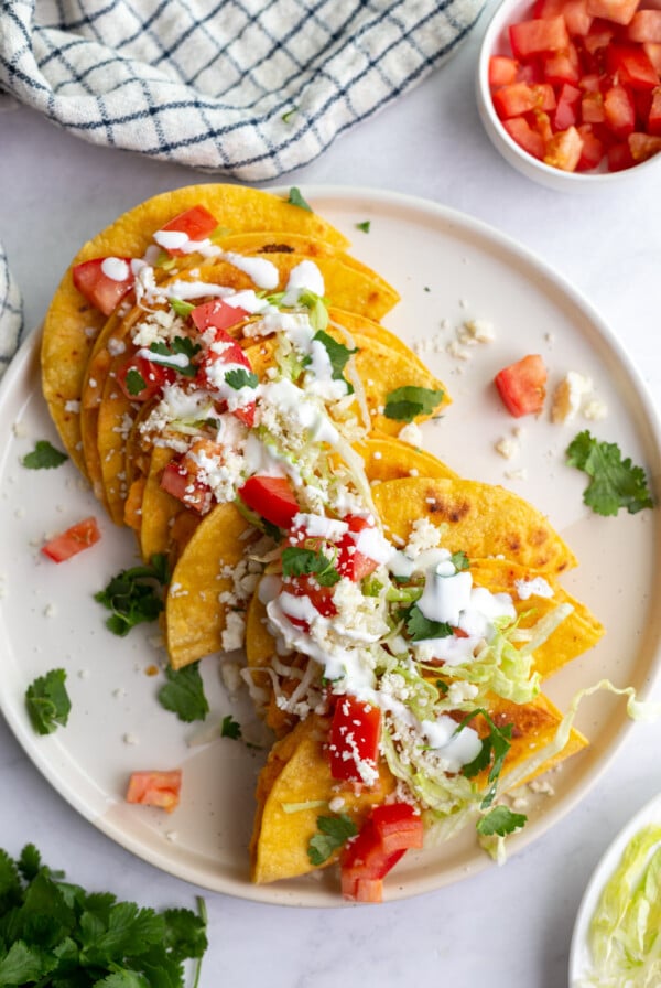 Potato Tacos topped with cheese on a white plate