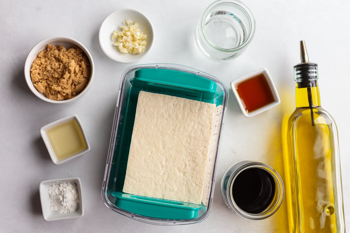 ingredients need to make sesame tofu including tofu, olive oil, sesame oil, soy sauce, garlic, corn starch and garlic