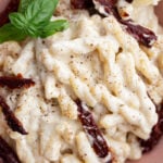 spiral pasta with creamy white sauce and topped with sun dried tomatoes