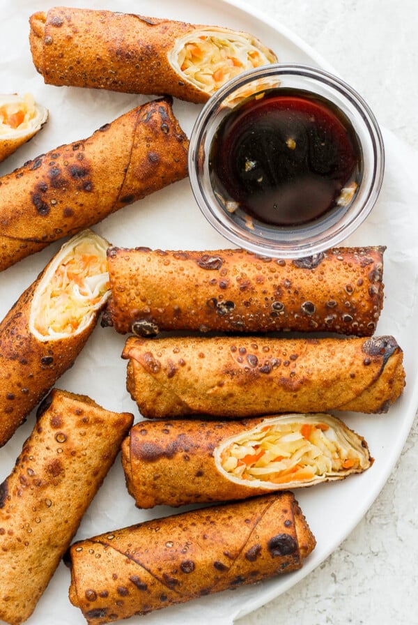 Vegan Egg Rolls on a white plate with sauce