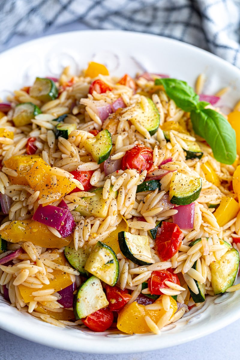 Roasted vegetable pasta salad topped with fresh basil.