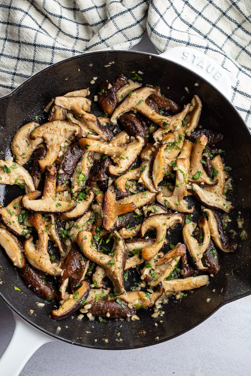 Sautéing shiitake mushrooms in a skillet.
