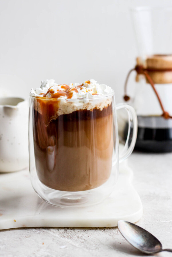 Caramel latte topped with whipped cream and caramel drizzle.