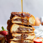 Drizzling syrup over a stack of Nutella stuffed French toast.