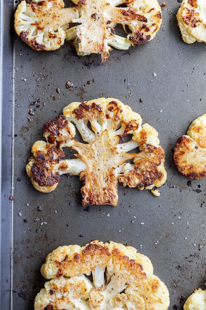 Roasted cauliflower on a baking sheet pan.