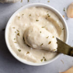 Spooning out Roasted Garlic Aioli from a small bowl.