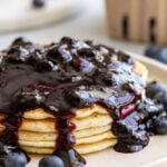 Blueberry syrup served over a stack of pancakes.