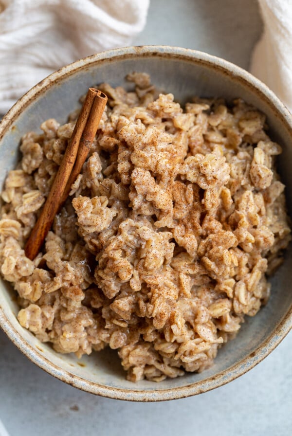 Oatmeal in a bowl with a cinnamon stick.