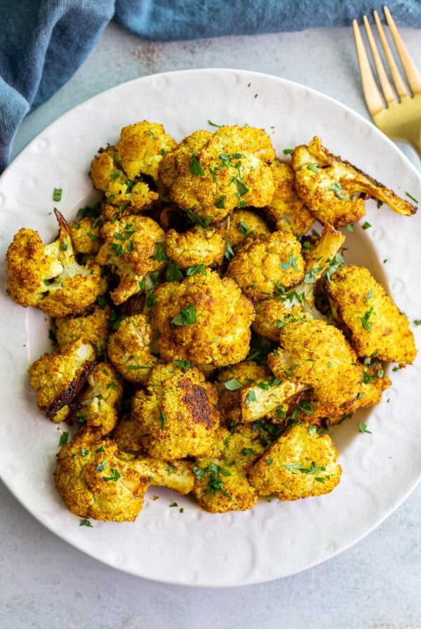 Curried cauliflower served in a white bowl.