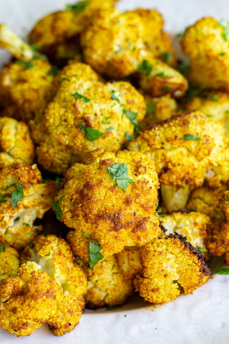 Roasted cauliflower garnished with fresh herbs.