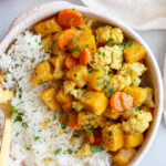 Pumpkin curry served over rice in a bowl.
