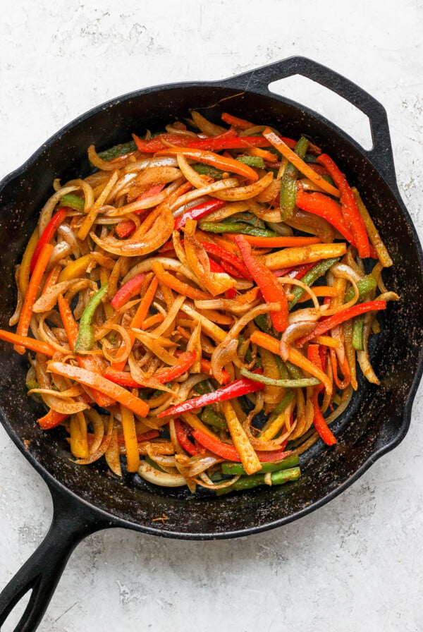 Sautéed bell peppers and onion in a cast iron skillet.