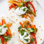 Fajitas made with flour tortillas, veggies, sour cream and cilantro.