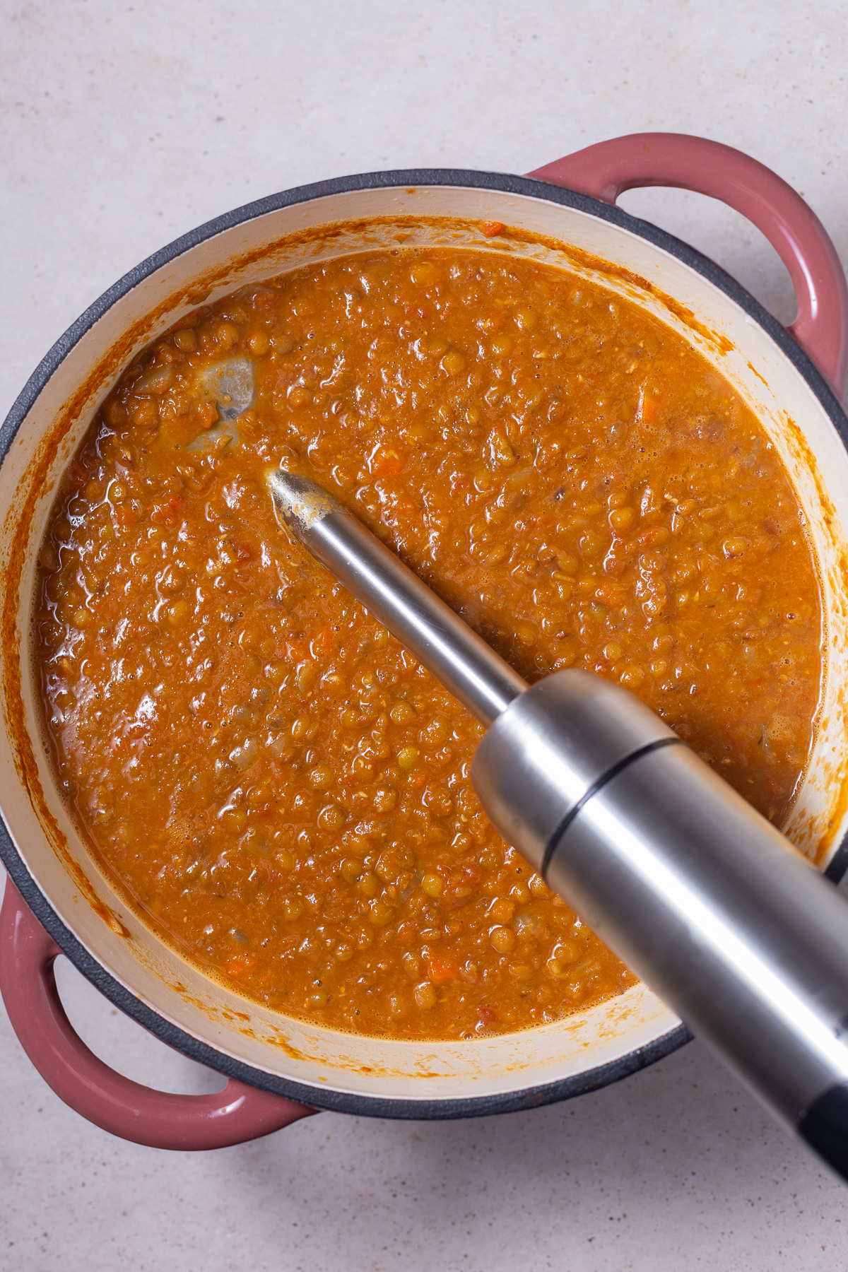 vegan lentil soup. ina pot with an immersion blender hanging out the side