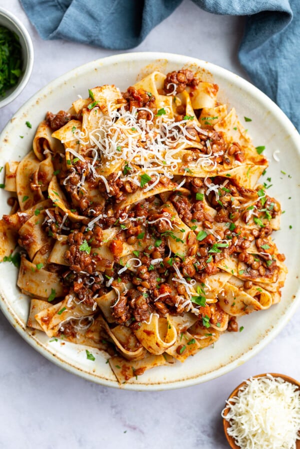 Lentil Bolognese served over pasta on a white plate.