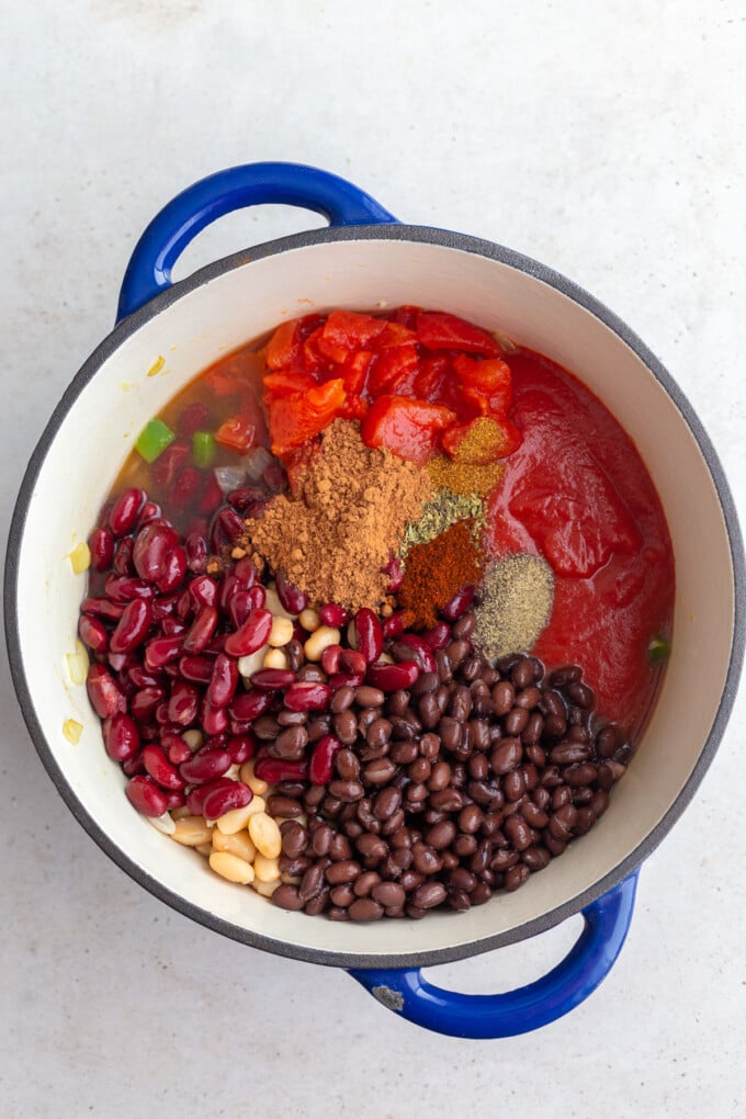 second step in making veggie chili: adding in the beans, spices, tomato sauce and diced tomatoes + broth