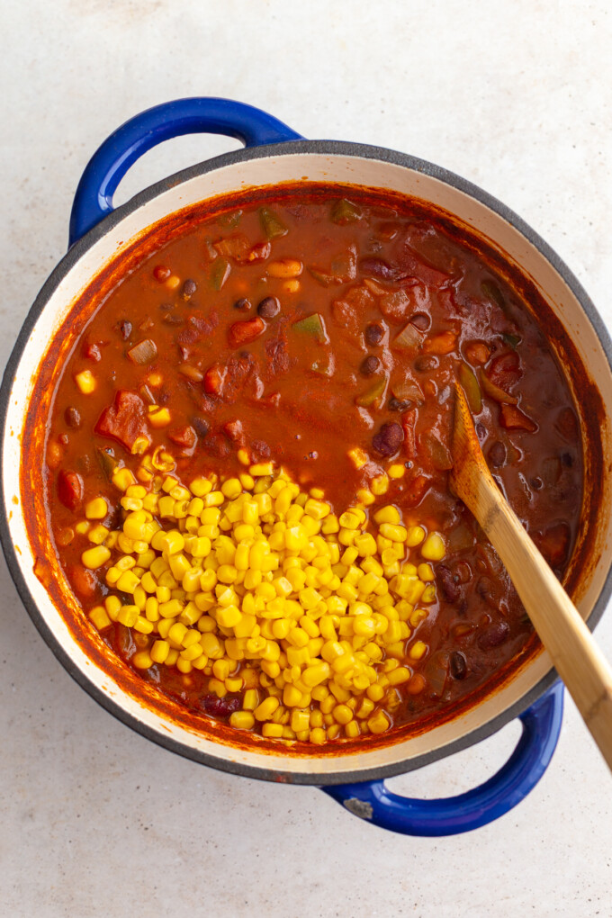 third step in making veggie chili: once it's cooked, add in the corn kernels