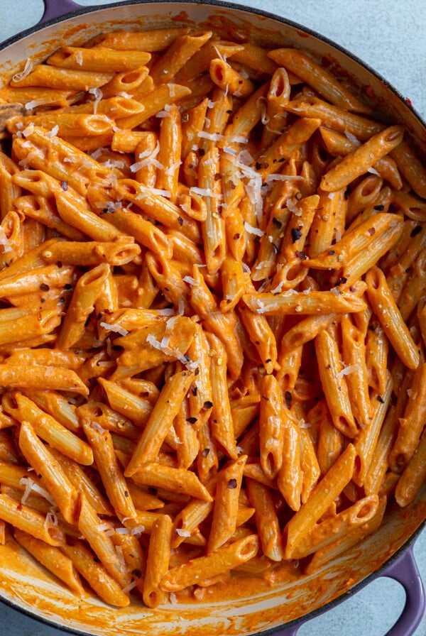 Penne pasta tossed in rose sauce in a large pot.