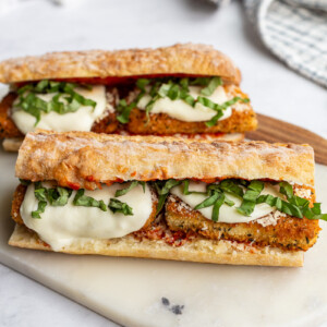 Tofu Parmesan Sandwiches on a marble cutting board.