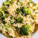 Broccoli Cheese Risotto served in a white bowl with a spoon.
