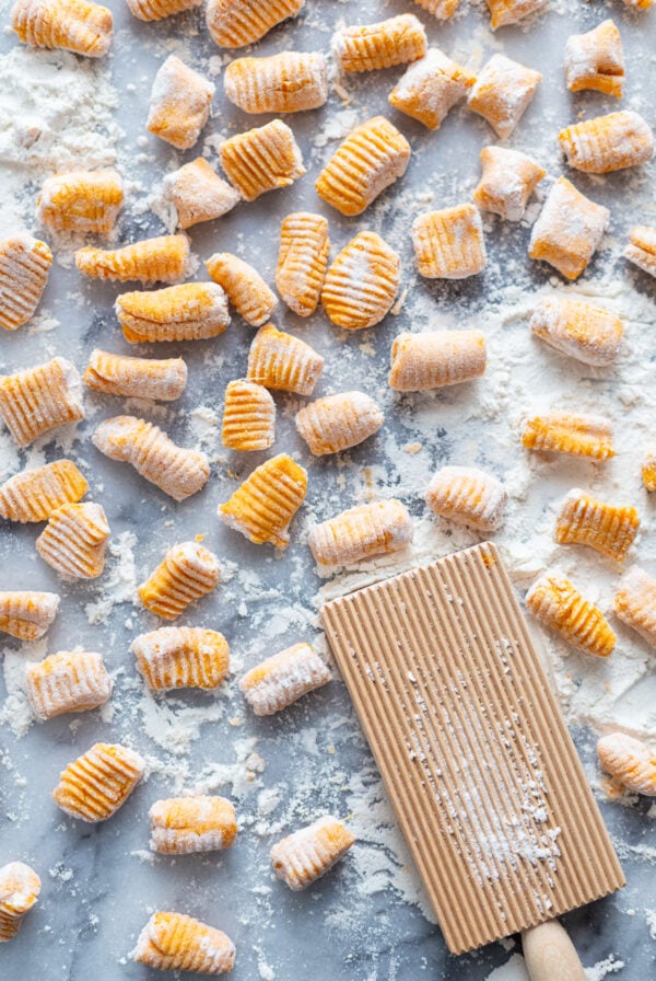 homemade sweet potato gnocchi on a large marble board with flour all over