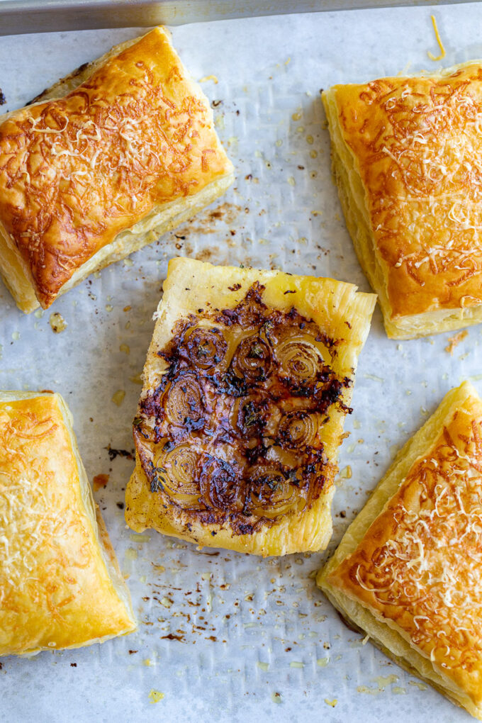 french onion tarts on a baking tray lined with parchment paper