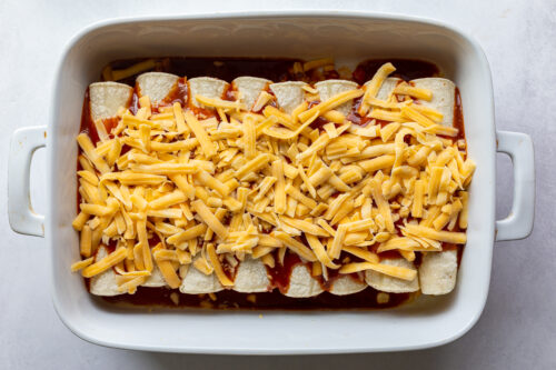 unbaked enchiladas with cheese on top