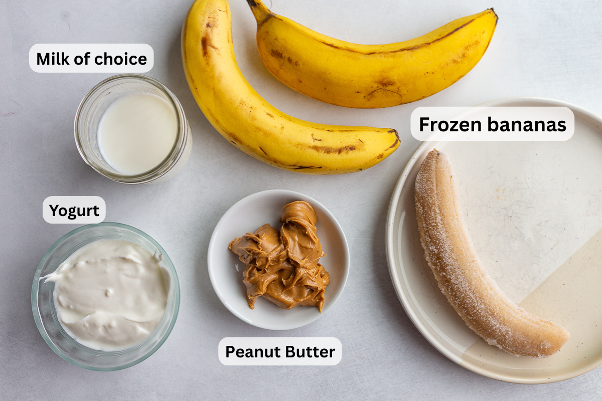 ingredients needed for peanut butter banana smoothie including bananas, peanut butter, milk, and yogurt