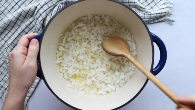 how to make lentil chili: onions sauteing in a dutch oven