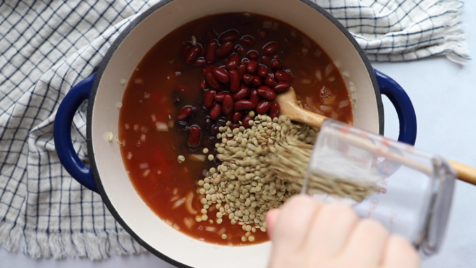 how to make lentil chili: all of the ingredients in a pot with the lentils going in