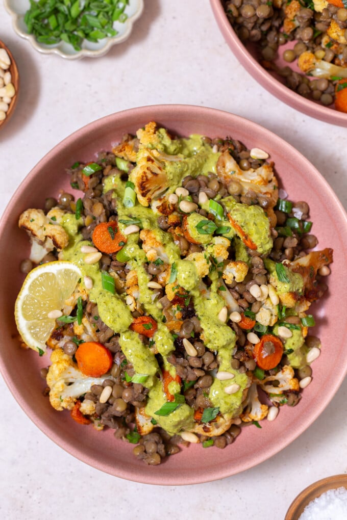 warm lentil salad topped with green goddess dressing and a lemon