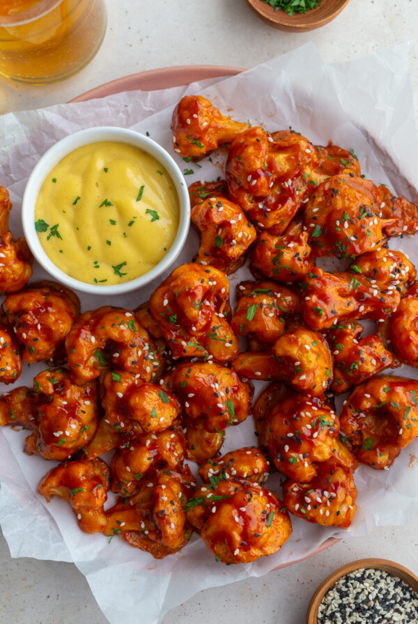 beer battered bbq cauliflower on a white tray with honey mustard in the corner