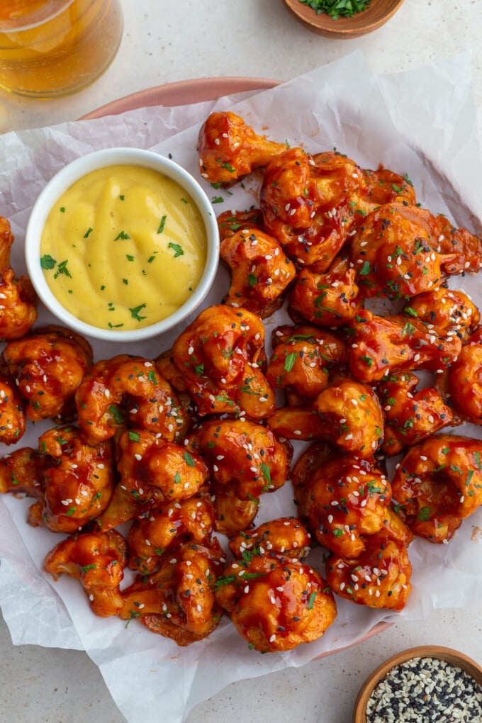 beer battered bbq cauliflower on a white tray with honey mustard in the corner