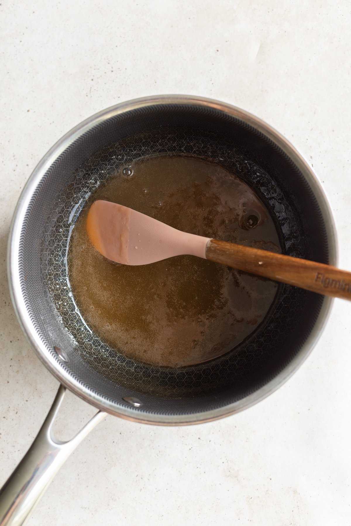 Stirring the gummy bear mixture in a saucepan.